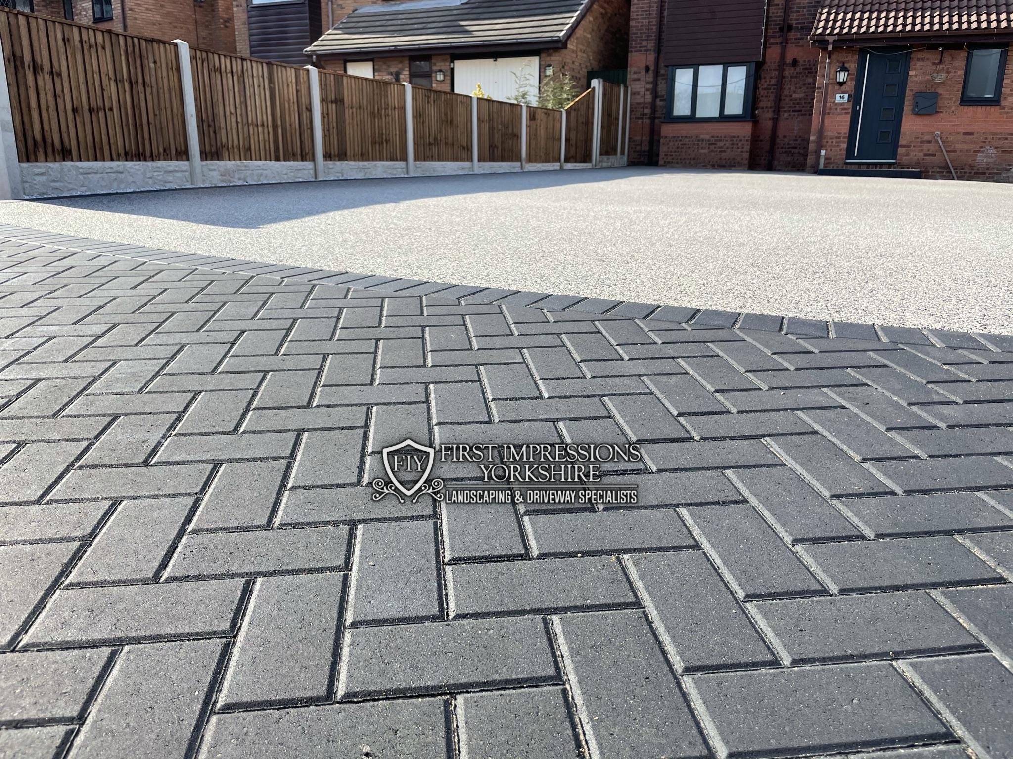 Charcoal block paved border meeting a resin bound driveway