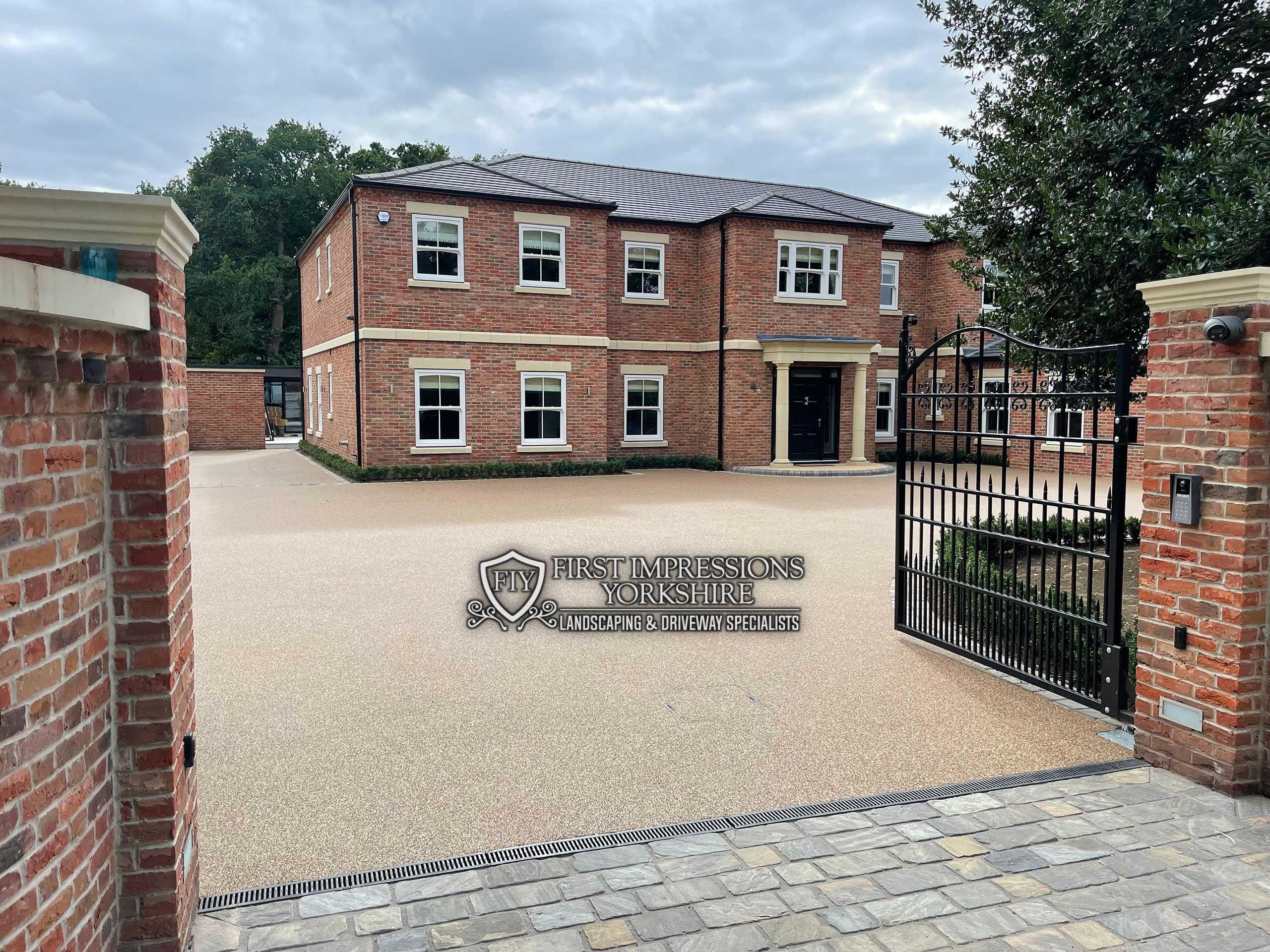 Large gated house with a sweeping gold resin bound driveway and channel drain